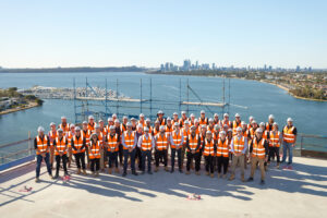 PACT construction staff standing on top of a building, wearing hard hats and reflective safety vests